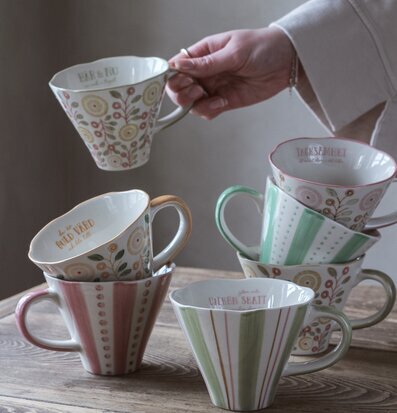 Foto av sex vackert dekorerade muggar i pastellfärger