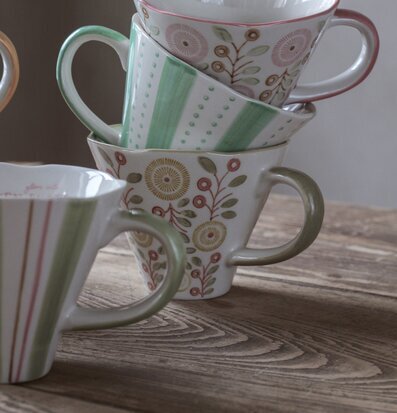 Bild av harmoniskt staplade, vackert dekorerade muggar