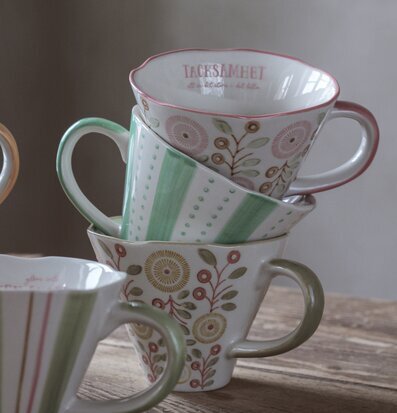 Foto av charmiga staplade muggar med blommönster