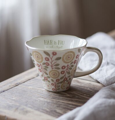 Bild av mugg med blommigt mönster och inspirerande text