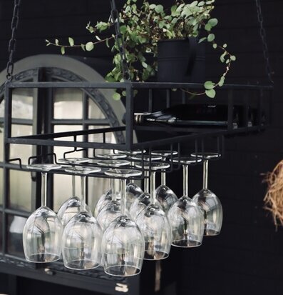 Foto av stilren hängande hylla med vinglas och växt