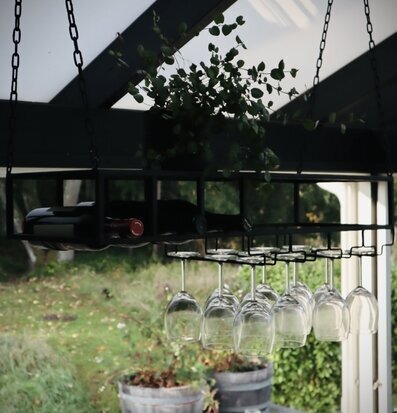 Bild av stilren hängande hylla med glas och vinflaskor