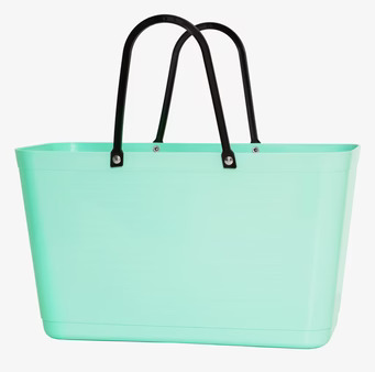 Foto av mintgrön väska med svarta handtag och stilren design