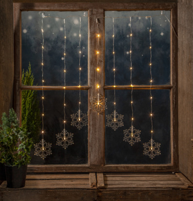 Foto av ljusgardin med snöflingor och vinterkänsla