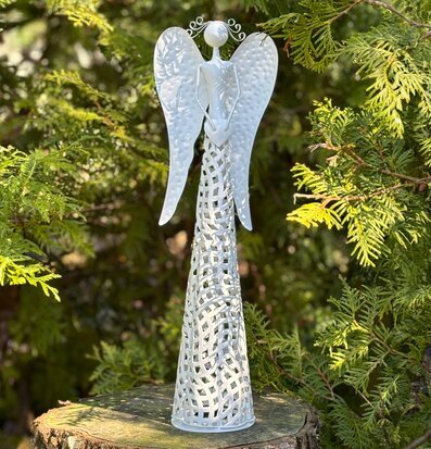Bild av stilren vit ängel i naturinspirerad miljö