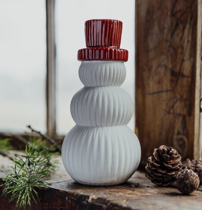 Bild av dekorativ snögubbe med röd hatt och träyta