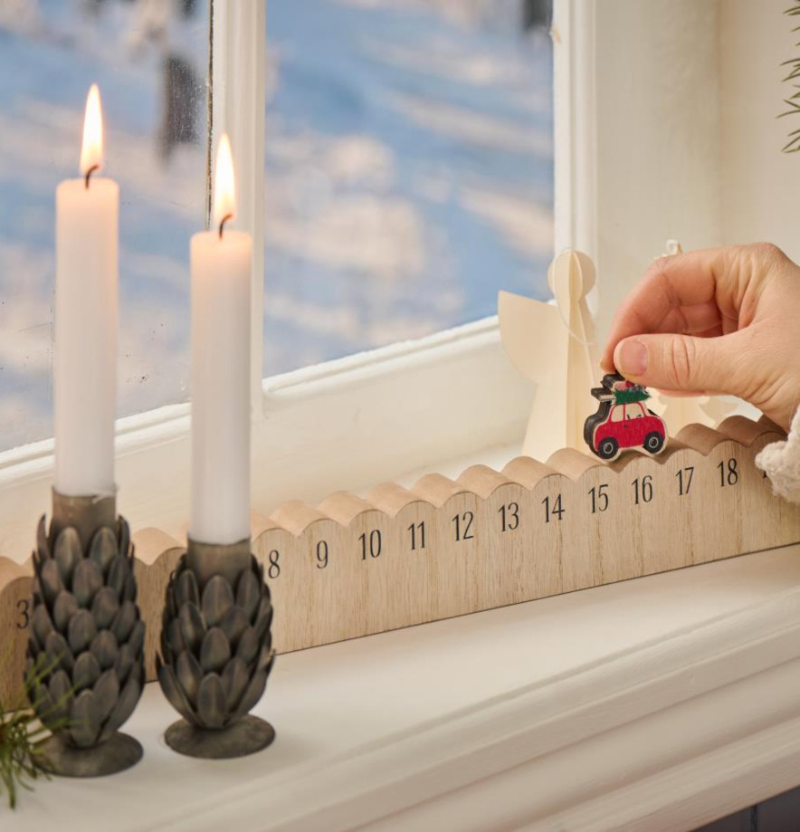 Julkalender 1-24 från IB Laursen på fönsterbräda med ljus