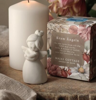 Bild av ängelstatyett och ljus i harmonisk miljö