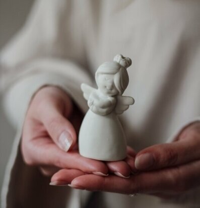 Bild av ängelfigur i händer, symbol för lugn och ro