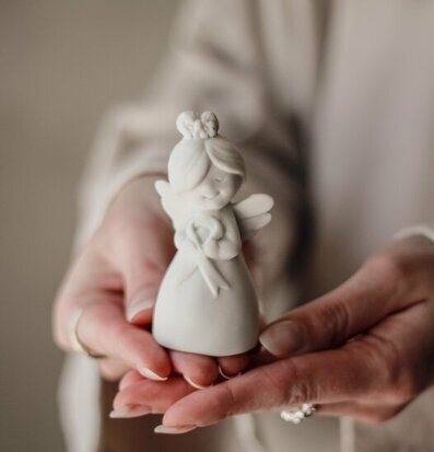Bild av ängelfigur i händer, symbol för hopp och omsorg