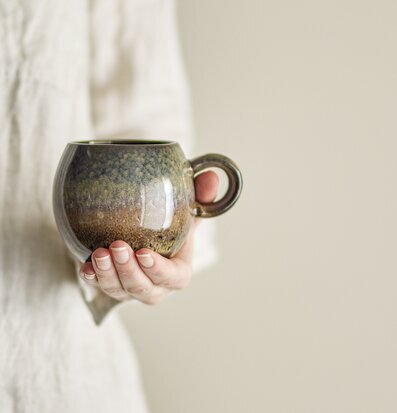 Bild av elegant brun mugg i stengods med hand