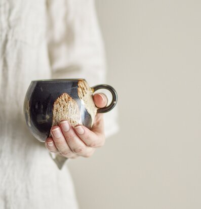 Bild av en handgjord mugg i stengods med brun nyans