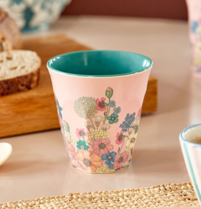 Bild av färgglad mugg med blommotiv i hemtrevlig miljö