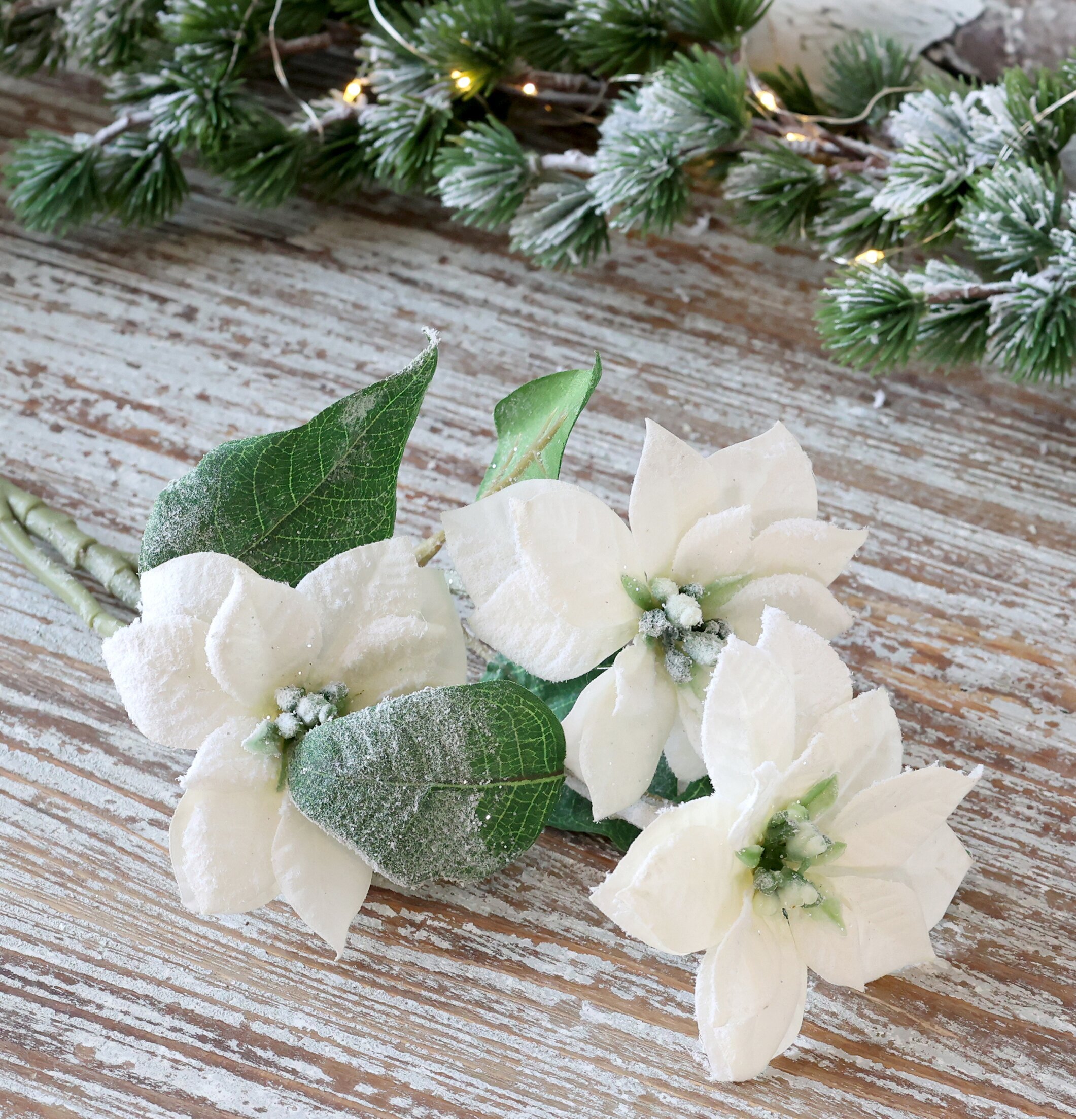 Bild av eleganta konstgjorda julstjärnor i vintermiljö