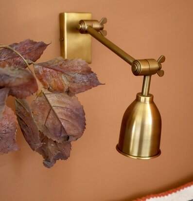 Bild av vägglampa i antik mässing och varm inredning