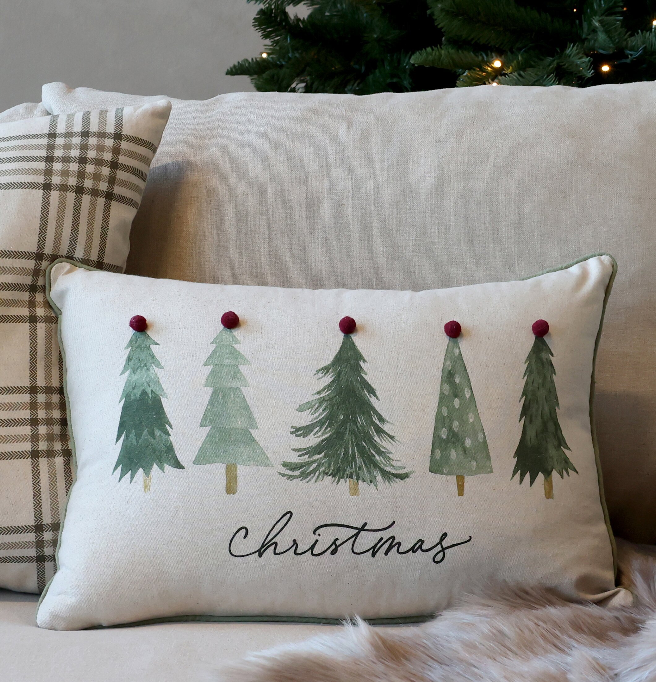 Bild av julinspirerad inredning med kuddar och gran