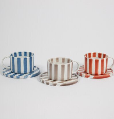 Bild av tre koppar med randmönster i olika färger