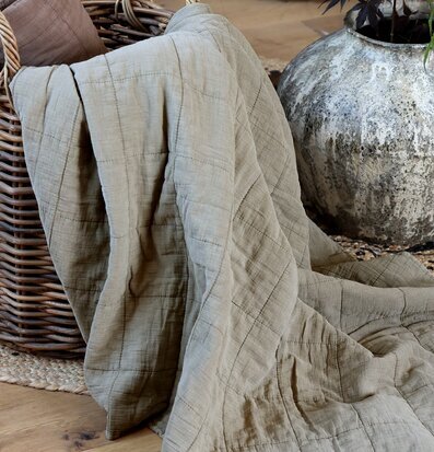 Bild av stilfullt arrangemang med quilt och rottingkorg