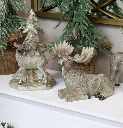 Bild av glittrande djurfigurer i skogsinspirerad miljö