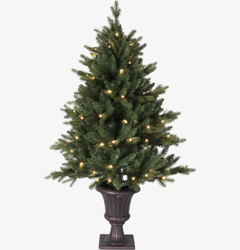 Foto av frodig julgran med LED-ljus och elegant fot