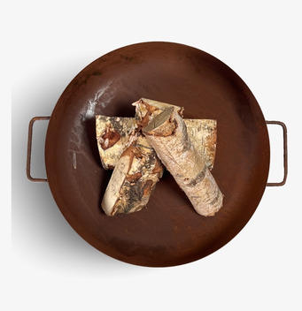 Foto av cirkulärt eldfat med rostig yta och vedträn