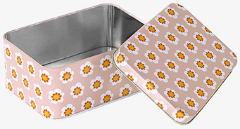 Bild på liten plåtburk med blommönster och rosa bakgrund