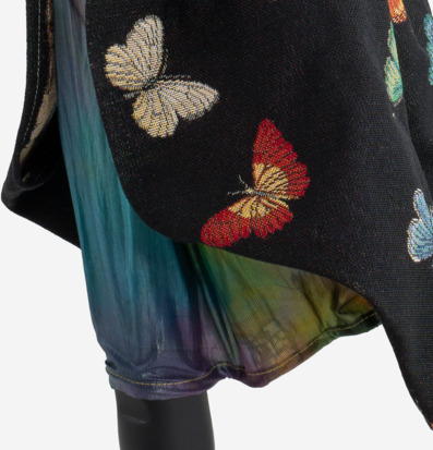 Bild av detaljrikt tyg med färgglada fjärilsmotiv