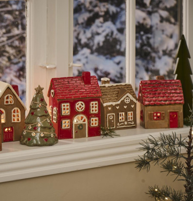 Foto av charmiga ljuslyktor som pepparkakshus i vintermiljö