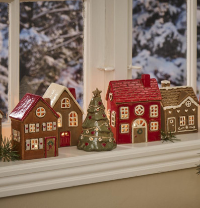 Bild av keramiska hus och julgran på fönsterbräda