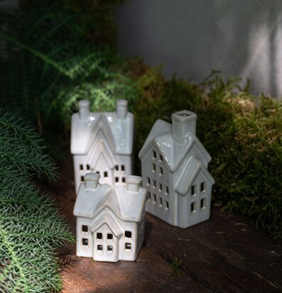 Bild av stämningsfulla keramikhus med ljus och grönska