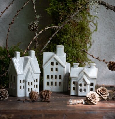 Bild av keramikhus i skogsmiljö med ljus och detaljer