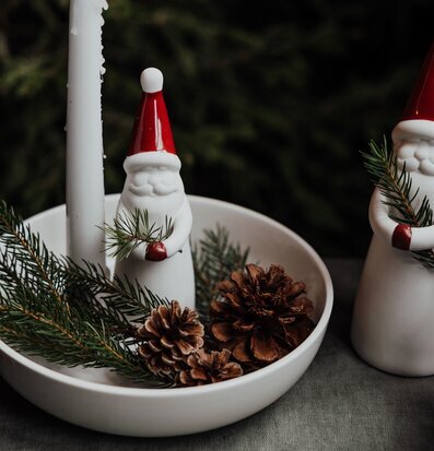 Bild av stämningsfullt vinterarrangemang med tomte och ljus