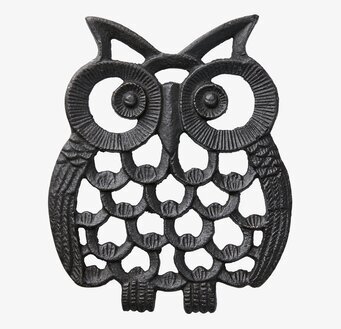 Bild av dekorativt ugglegrytunderlägg i mörk metall