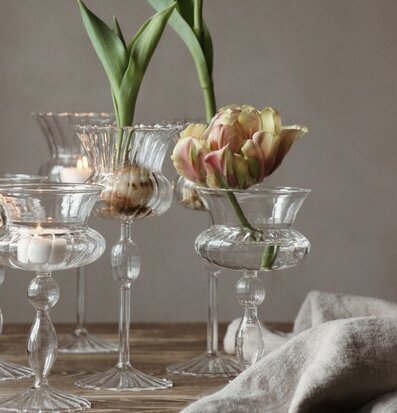 Bild av smakfullt arrangerat bord med glasvas och tulpaner