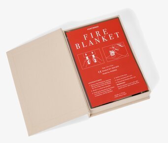 Bild av stilren brandfilt i beige låda med röd etikett