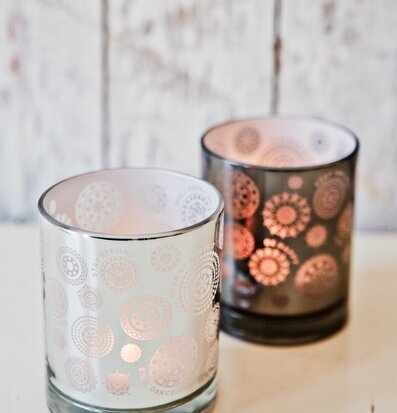 Bild av två röktonade ljushållare med cirkulära mönster