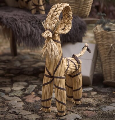 Bild av traditionell julbock i halm med rustik bakgrund