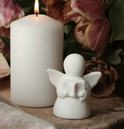 Bild av harmonisk scen med ängel, ljus och blommor