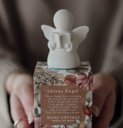 Bild av dekorativ ängelfigur med blommönstrad box