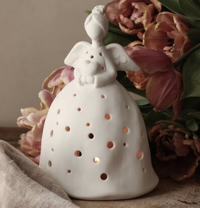 Bild av dekorativ ängelfigur med ljusinsläpp och blommor