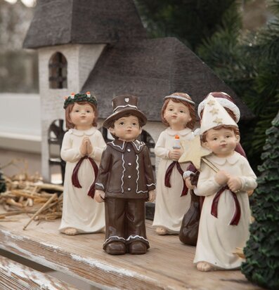 Bild av stämningsfullt luciatåg framför kyrkomodell