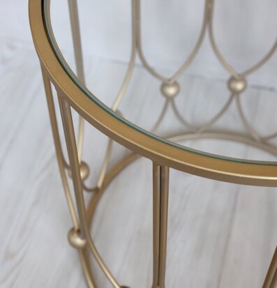 Bild av elegant sidobord i glas och metall med gyllene ton