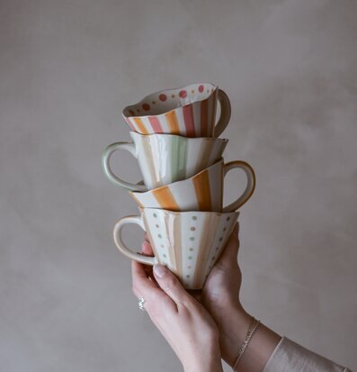 Bild av tre staplade muggar med prickar och ränder