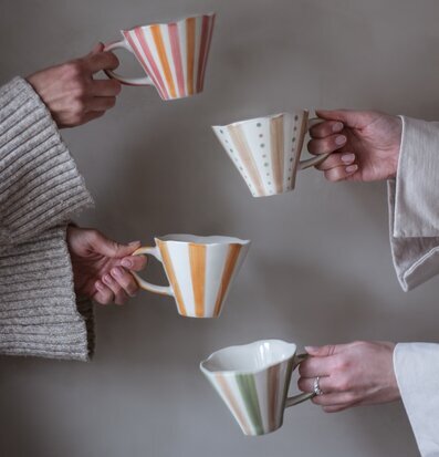 Bild av färgglada randiga muggar i gemenskap och värme