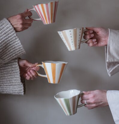 Bild av stilfulla muggar med randiga och jordnära mönster