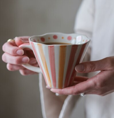 Bild av en mugg med lekfullt mönster och mjukt ljus