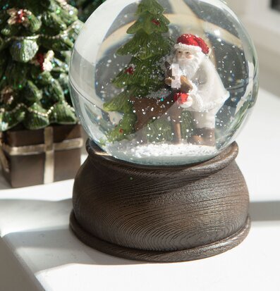 Bild av snöglob med tomte och rådjur i vinterlandskap