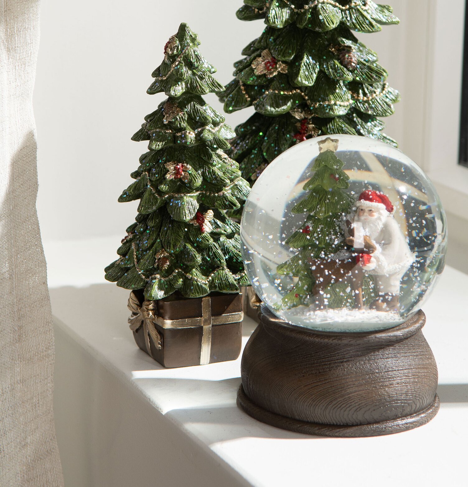 Bild av juldekorationer med snöglob och julgranar