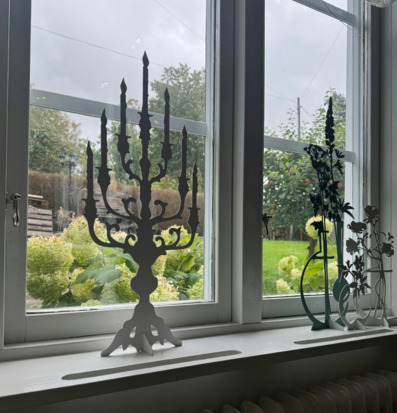 Bild av elegant kandelaber i stilrent fönsterarrangemang