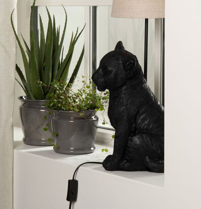 Foto av dekorativ lampfot med lejonunge och växter